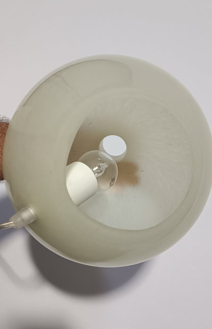 Vista superior do candeeiro Halo Brando aceso, com brilho suave visível na superfície.