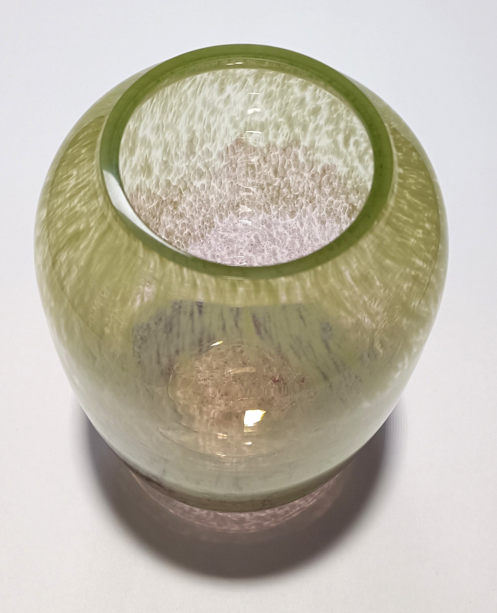 Vista superior do vaso em vidro verde e rosa com efeito espuma.