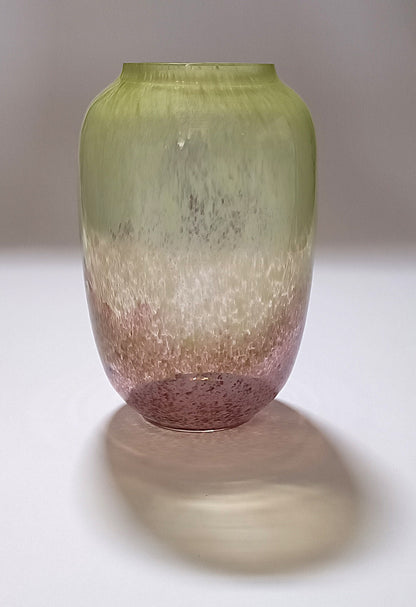 Vaso verde e rosa com efeito espuma, fotografado com sombra projetada no fundo branco.